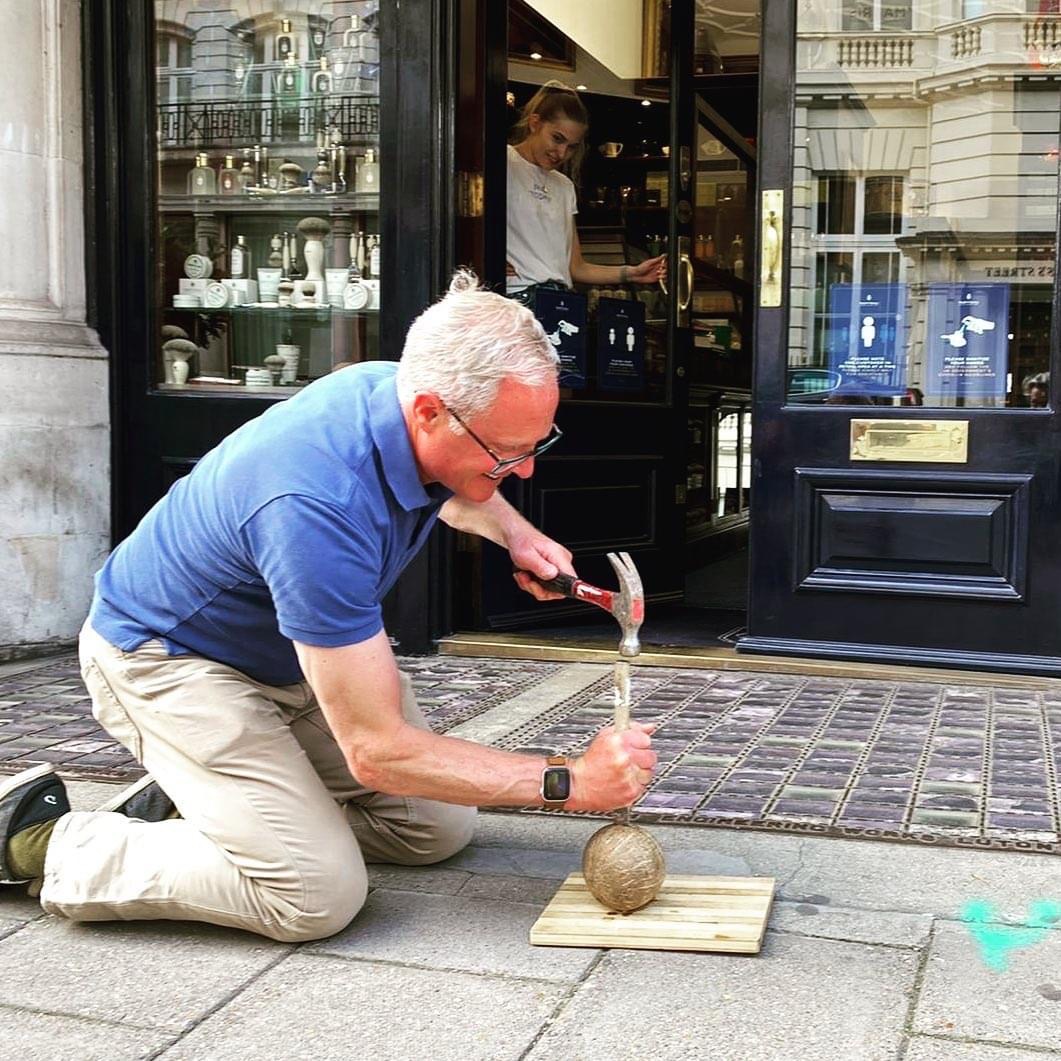 Mark Weeks crack a coconut on the street for art